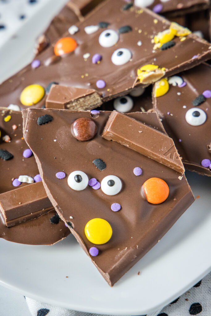 chocolate halloween bark cut in pieces on a white plate