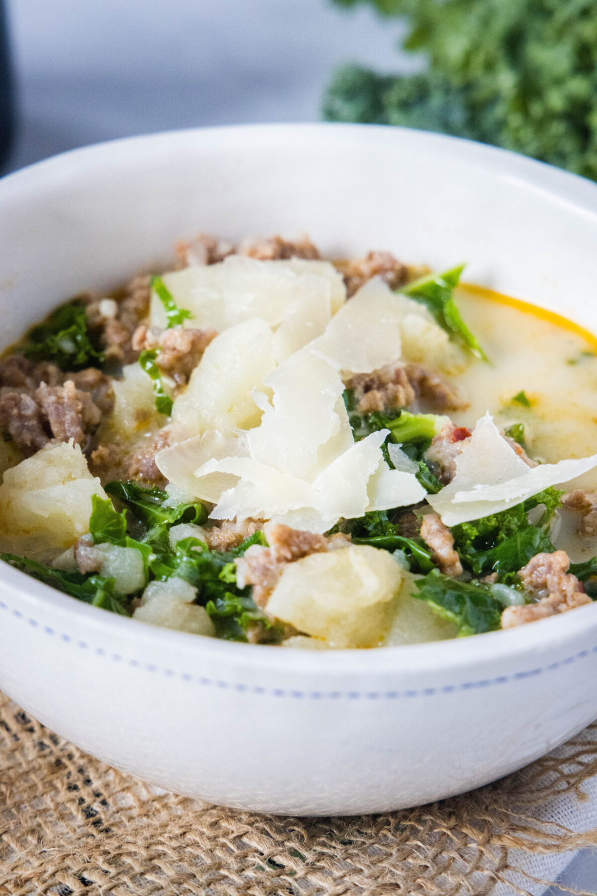 Close up of a bowl of Zuppa Toscana topped with parmesan