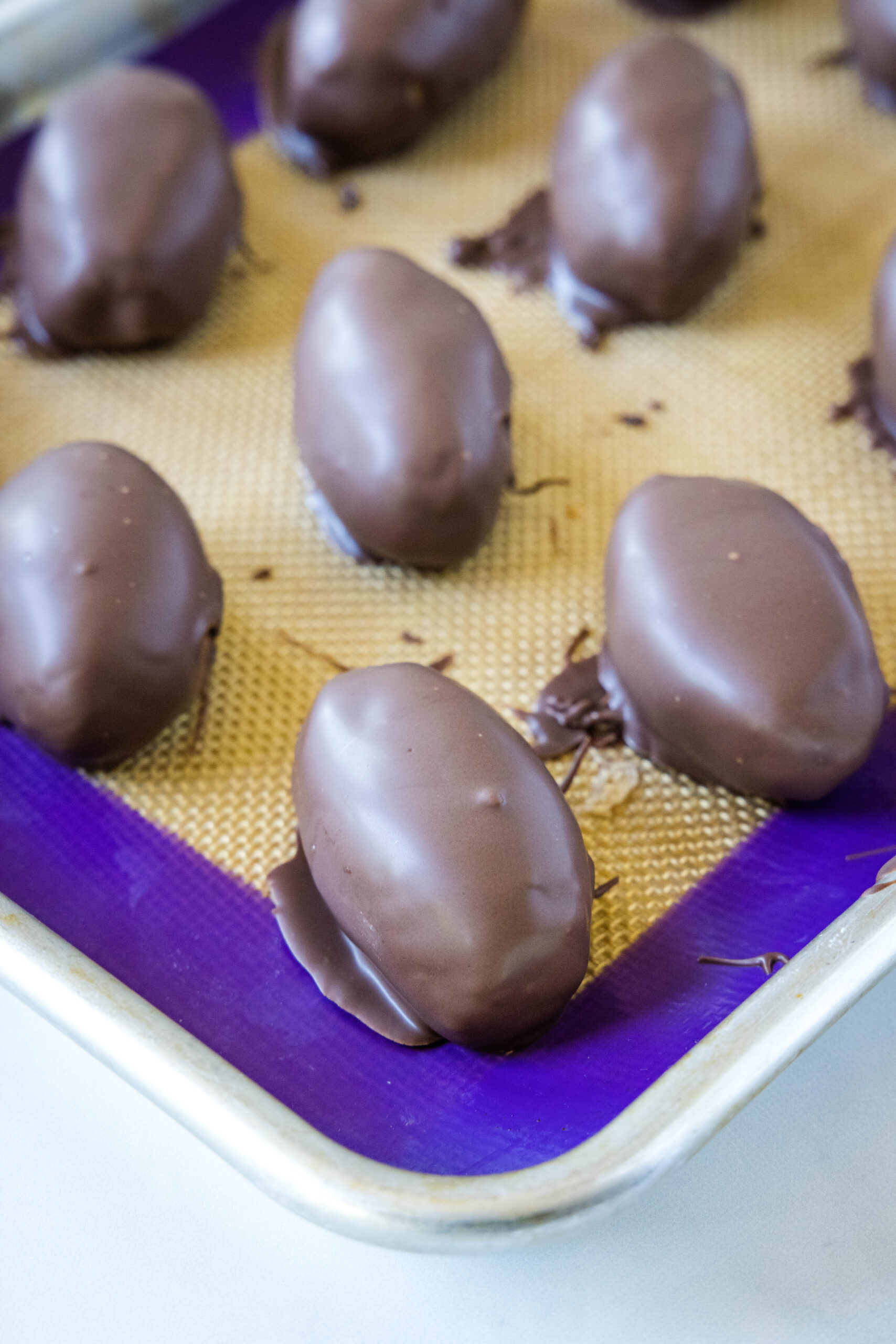 chocolate dipped footballs on baking tray