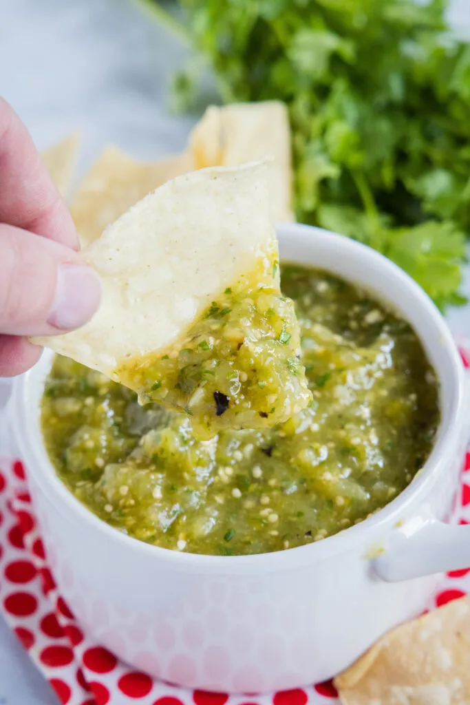 scooping salsa verde onto a chip