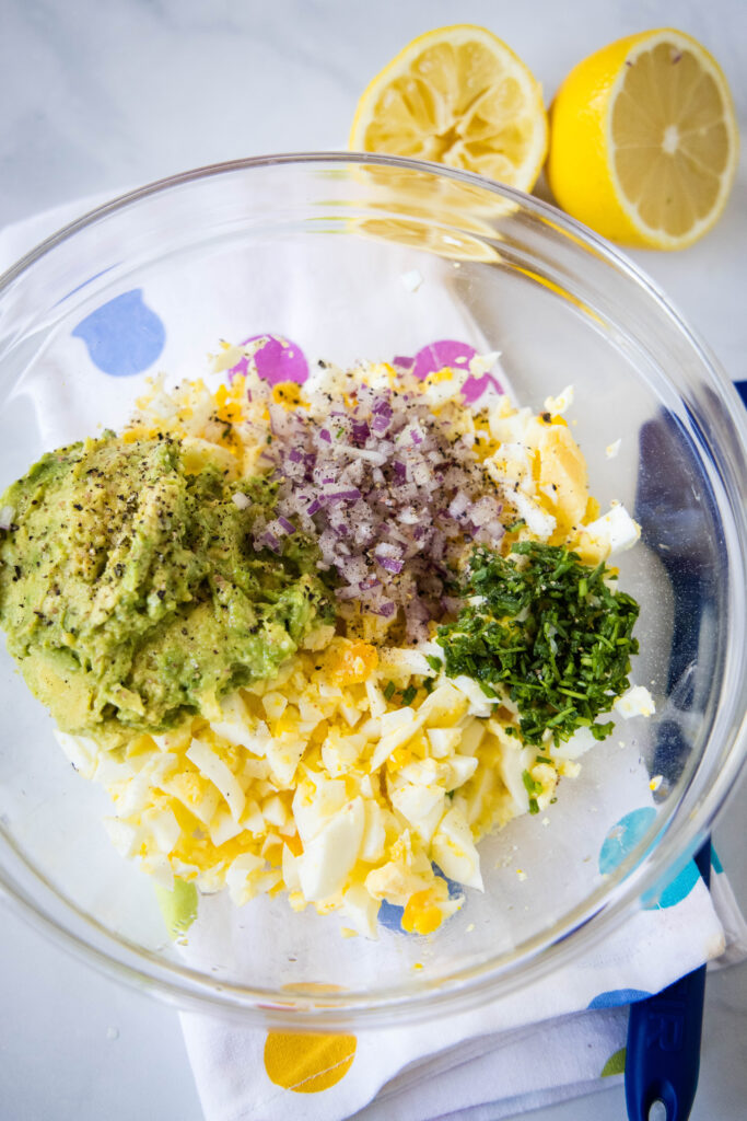 mixing together avocado egg salad in a bowl