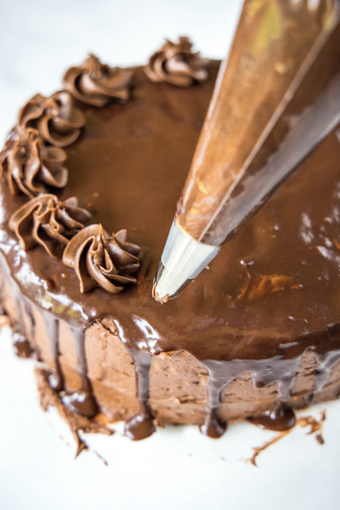 piping chocolate swirls on cake