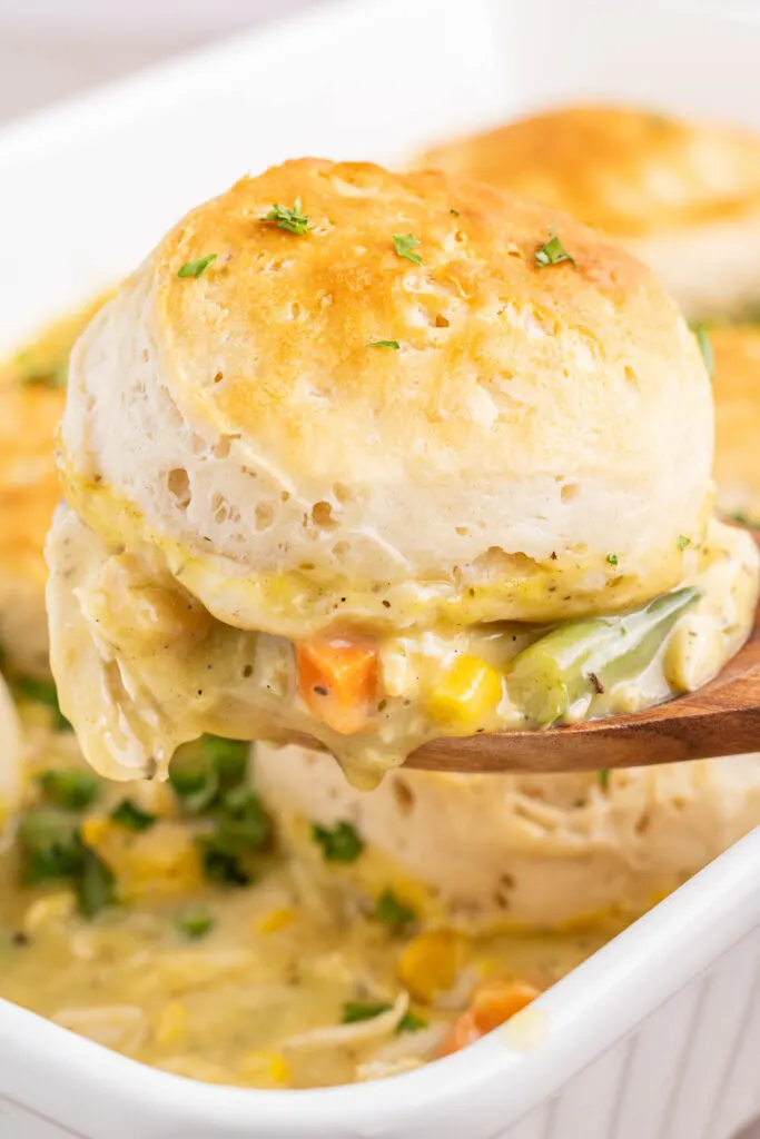 scooping chicken pot pie casserole out of baking dish