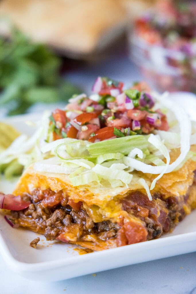 sheet taco topped with lettuce and pico de gallo on a plate