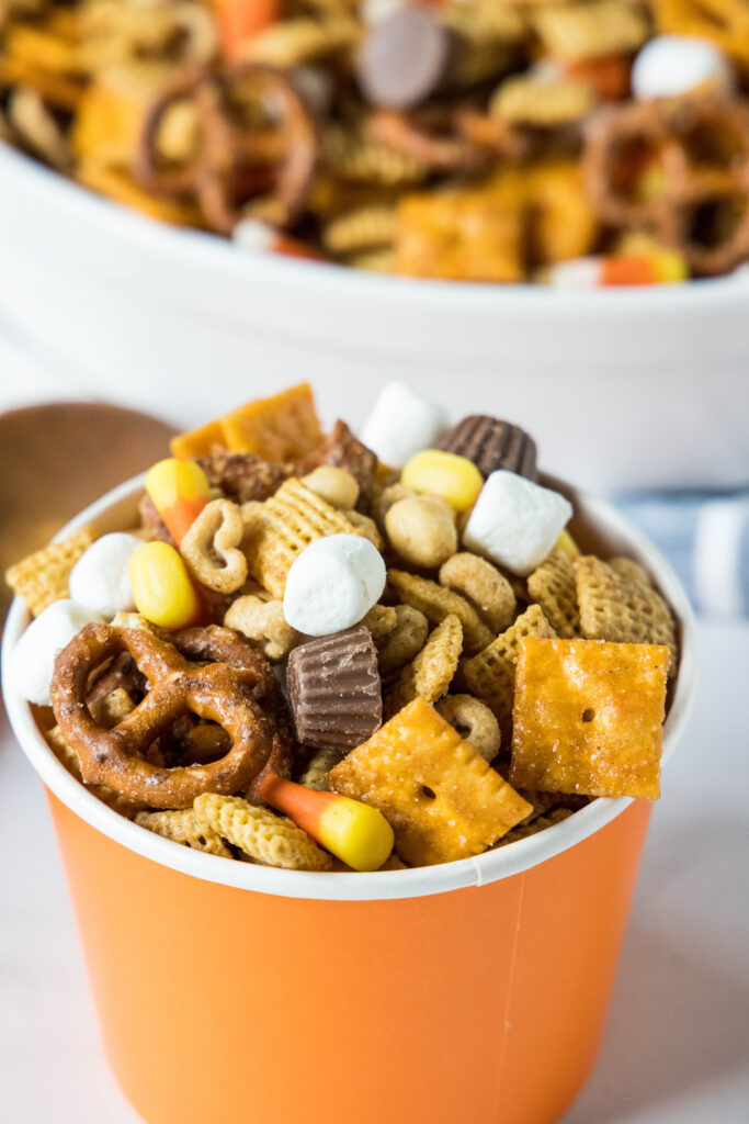 fall snack mix in an orange cup