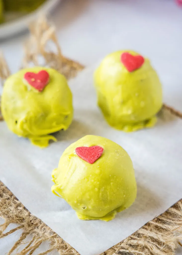 grinch truffles on a pieces of parchment paper