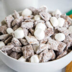 close up hot chocolate muddy buddies in a white bowl