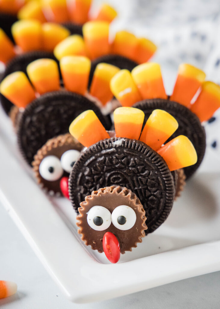 oreo turkey cookies standing up on a white serving tray