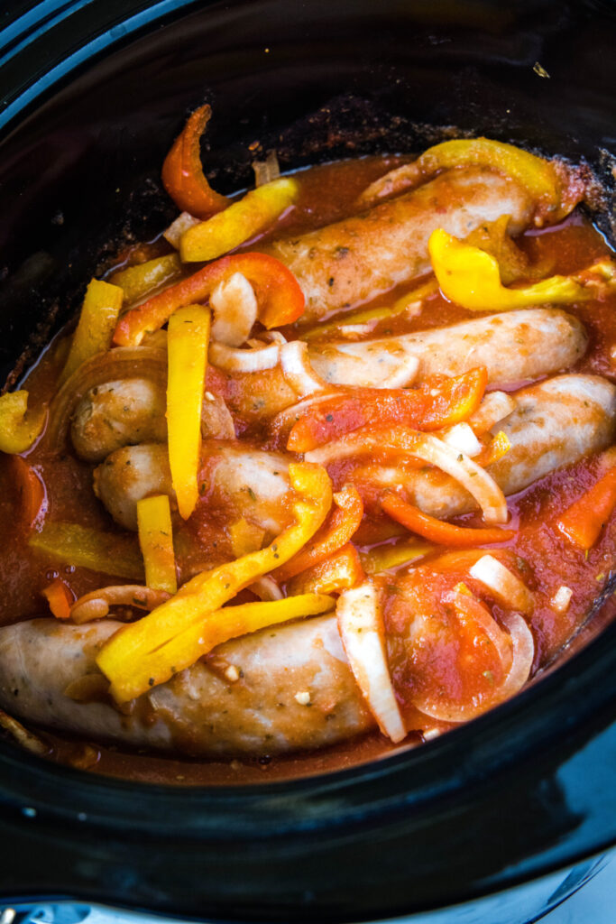 Sausage, peppers, onions, and tomato sauce mixed together in a crock pot