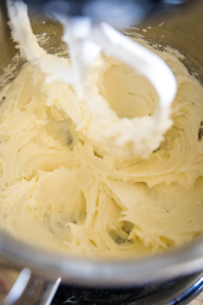 Close up of vanilla frosting being whipped in a stand mixer