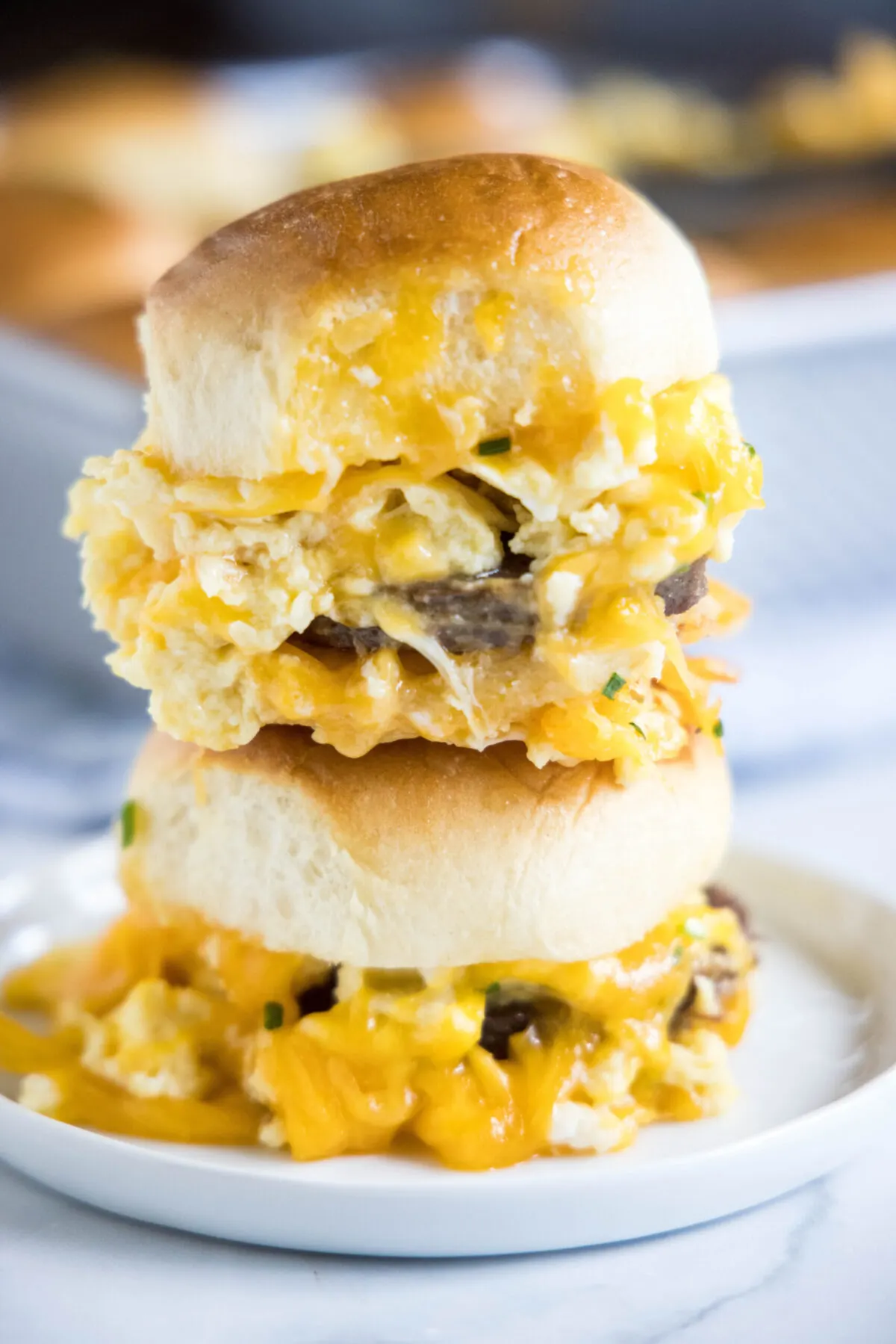 A plate with two breakfast sliders stacked on top of each other