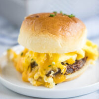 Close up of a breakfast slider on a plate, with melted cheese