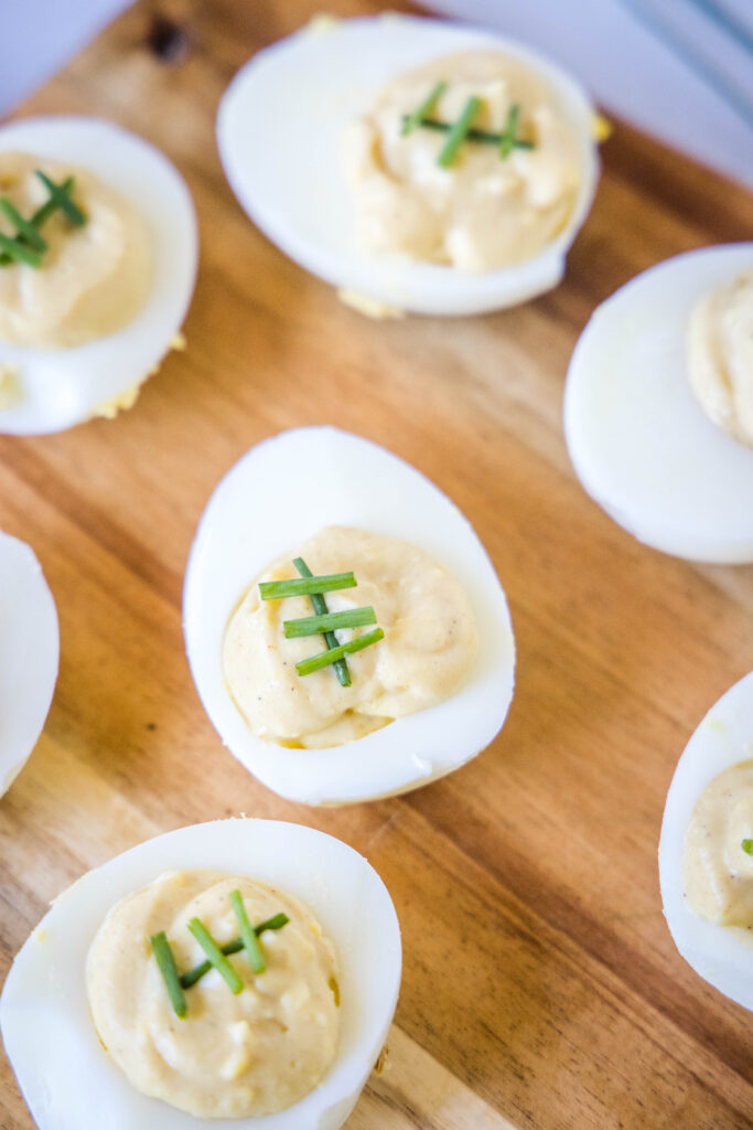 deviled eggs topped with chives to look like footballs