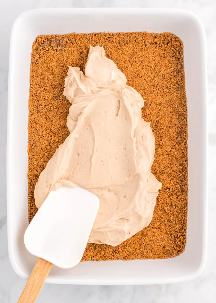 spreading cinnamon cream cheese over gingersnap crust