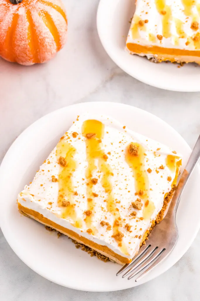a slice of layered pumpkin dessert on a white plate