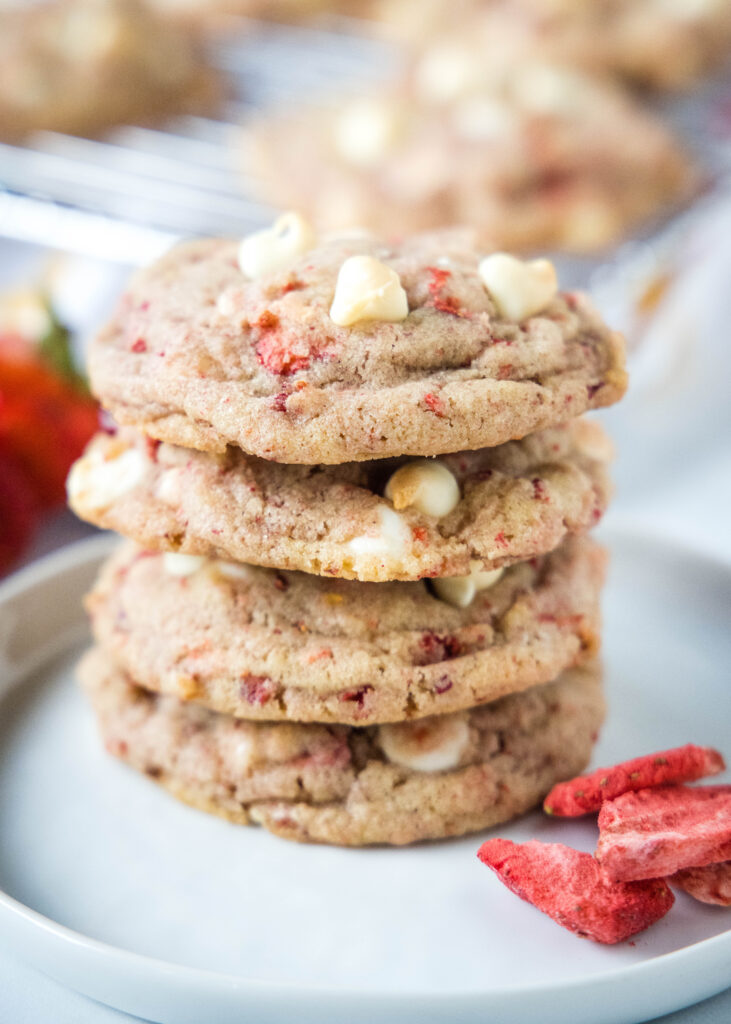 strawberry white chocolate cookies stacked on a white plate
