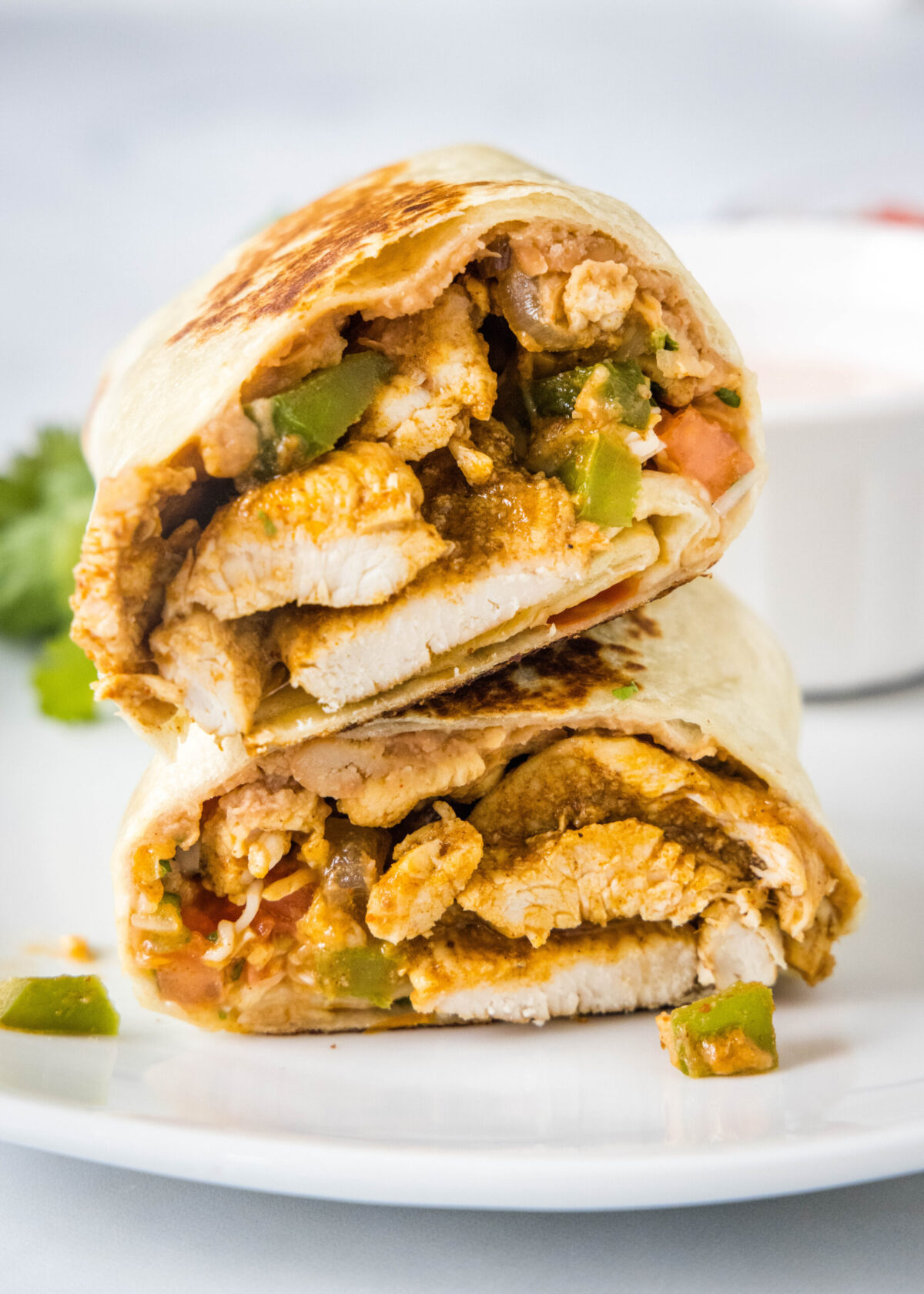 Two halves of a chicken fajita wrap stacked on top of each other.