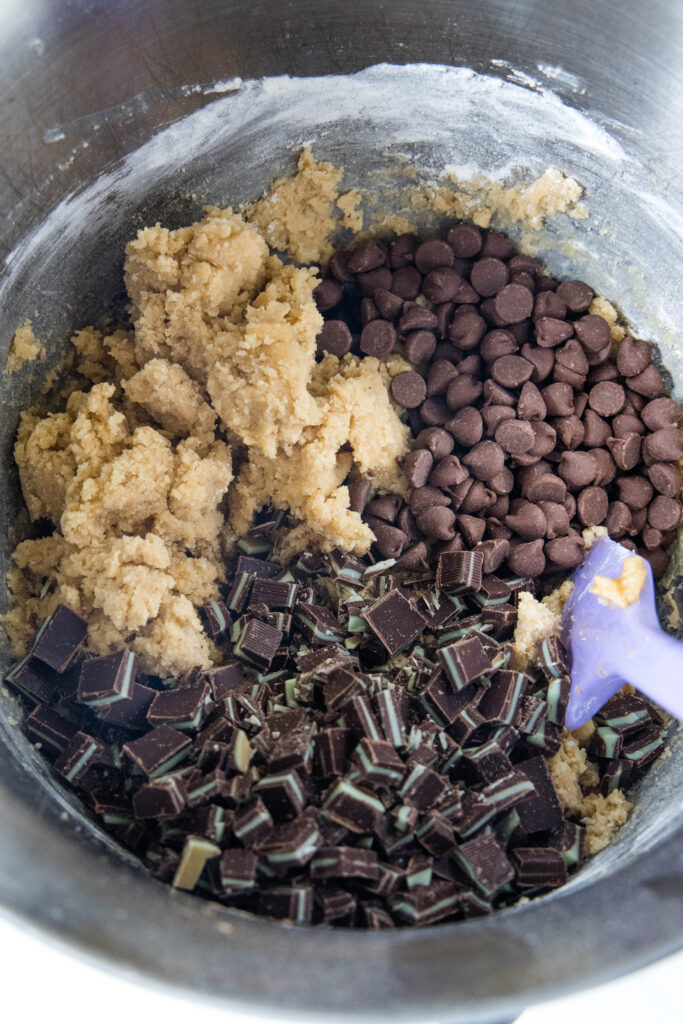 adding chocolate chips and andes mints to cookie dough