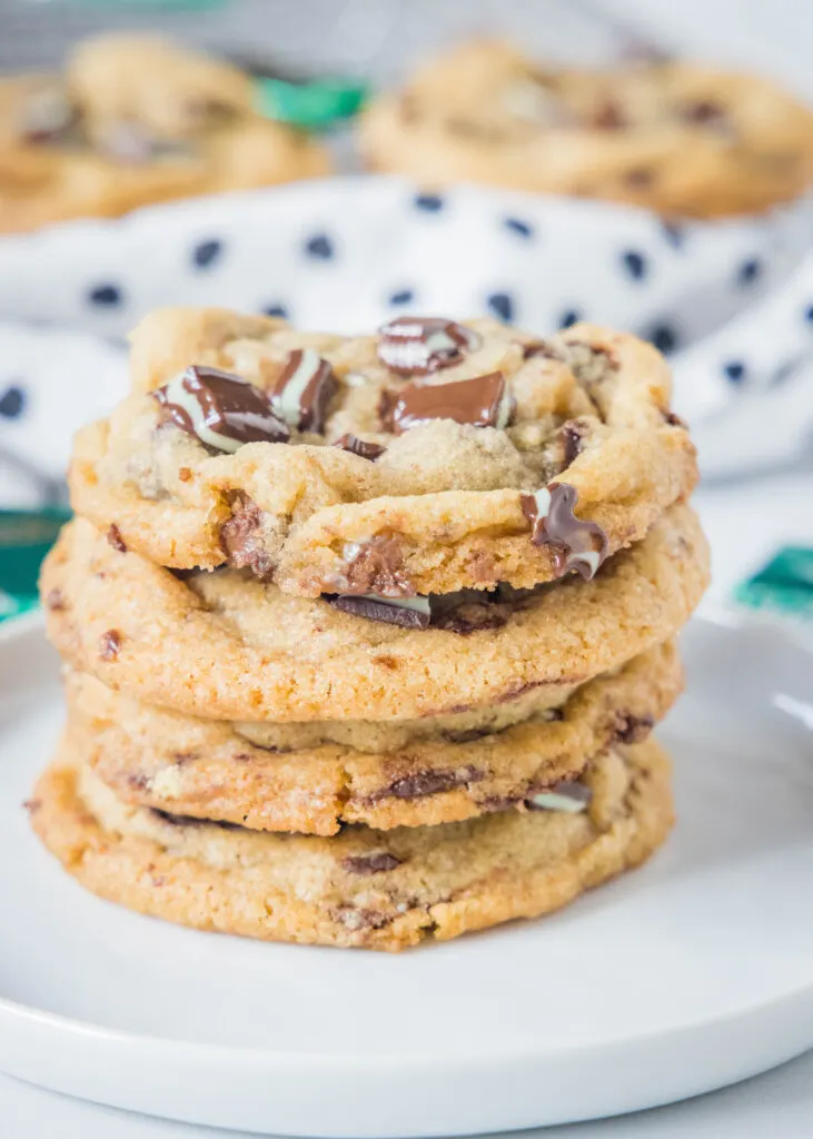 stacked mint chocolate chip cookies on a white plate
