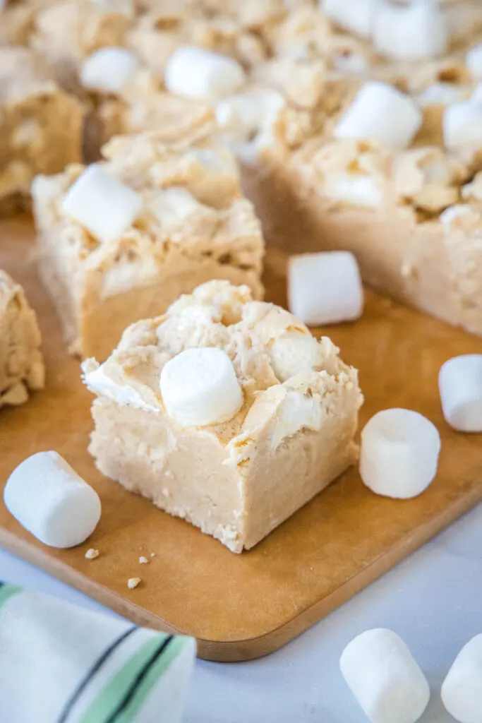 a cutting board with pieces of peanut butter marshmallow fudge