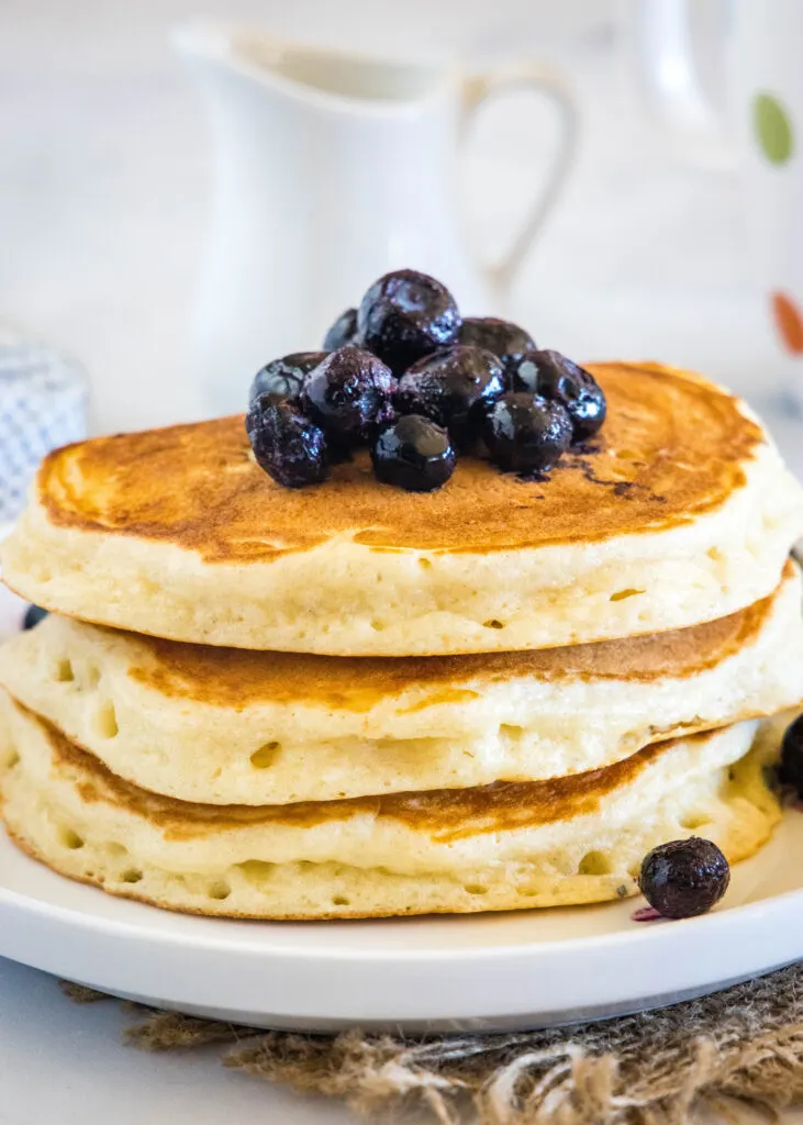 stack of pancakes topped with blueberries