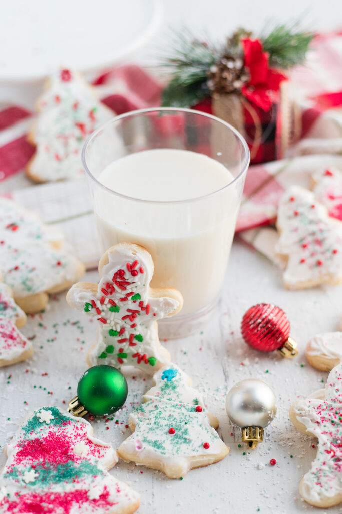 frosted sugar cookies around a glass of milk
