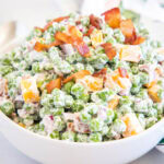 Pea salad in a white bowl.