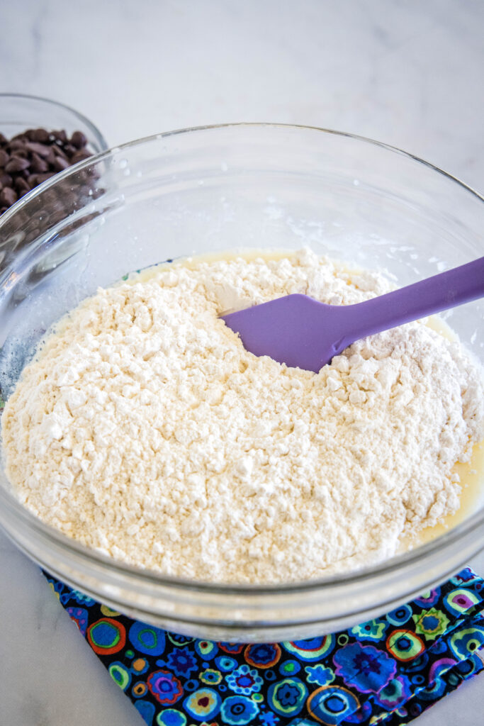 Dry ingredients added to a bowl of buttermilk muffin batter.