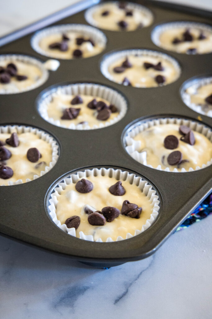 Unbaked chocolate chip buttermilk muffin batter in a muffin pan.