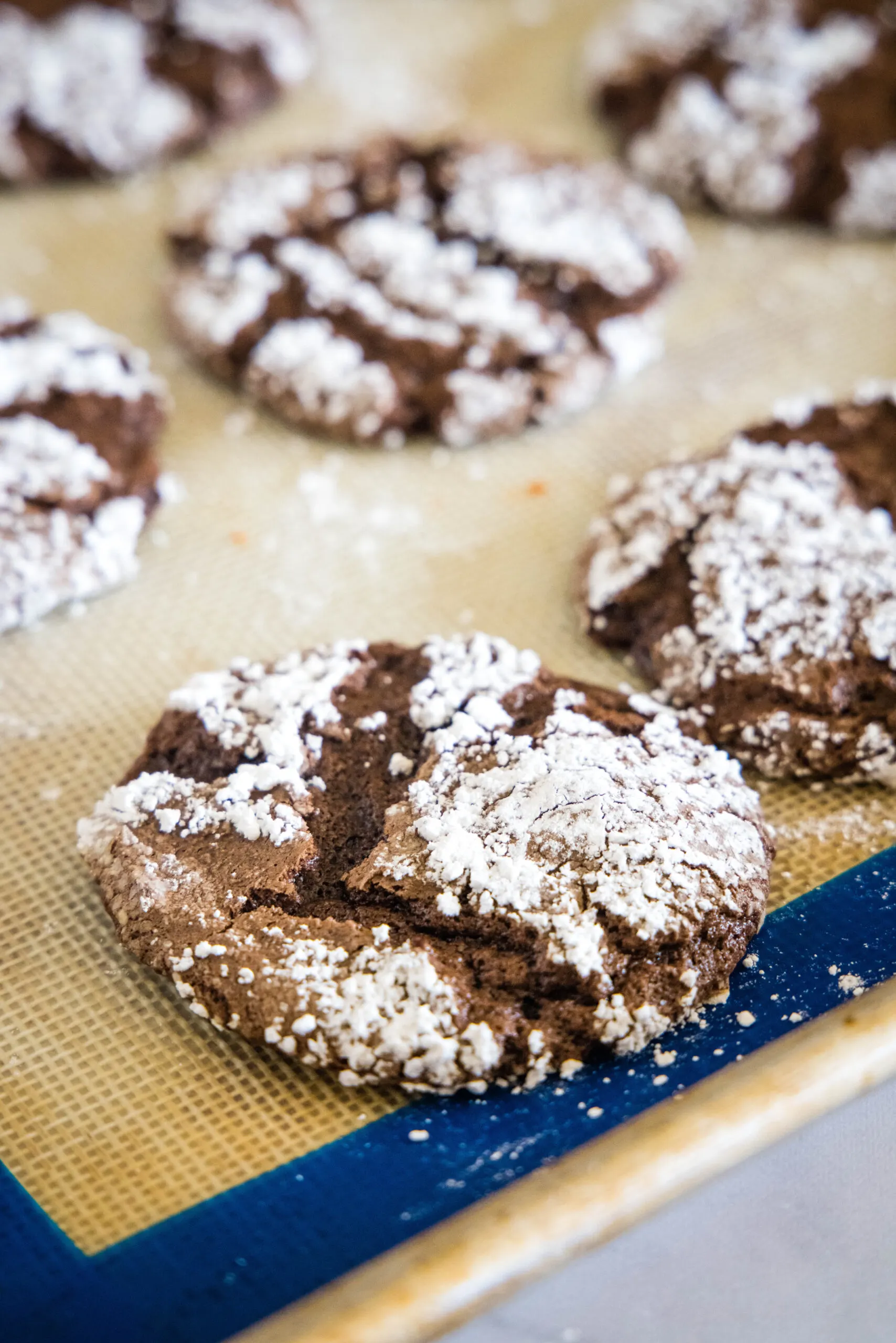 Baked chocolate Cool Whip cookies on a lined baking sheet.