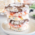 Assorted Cool Whip cookies stacked on a white plate.