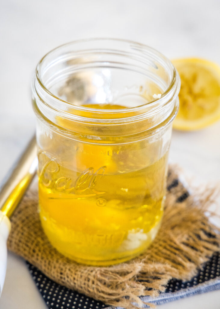 Oil and eggs combined in a glass mason jar.