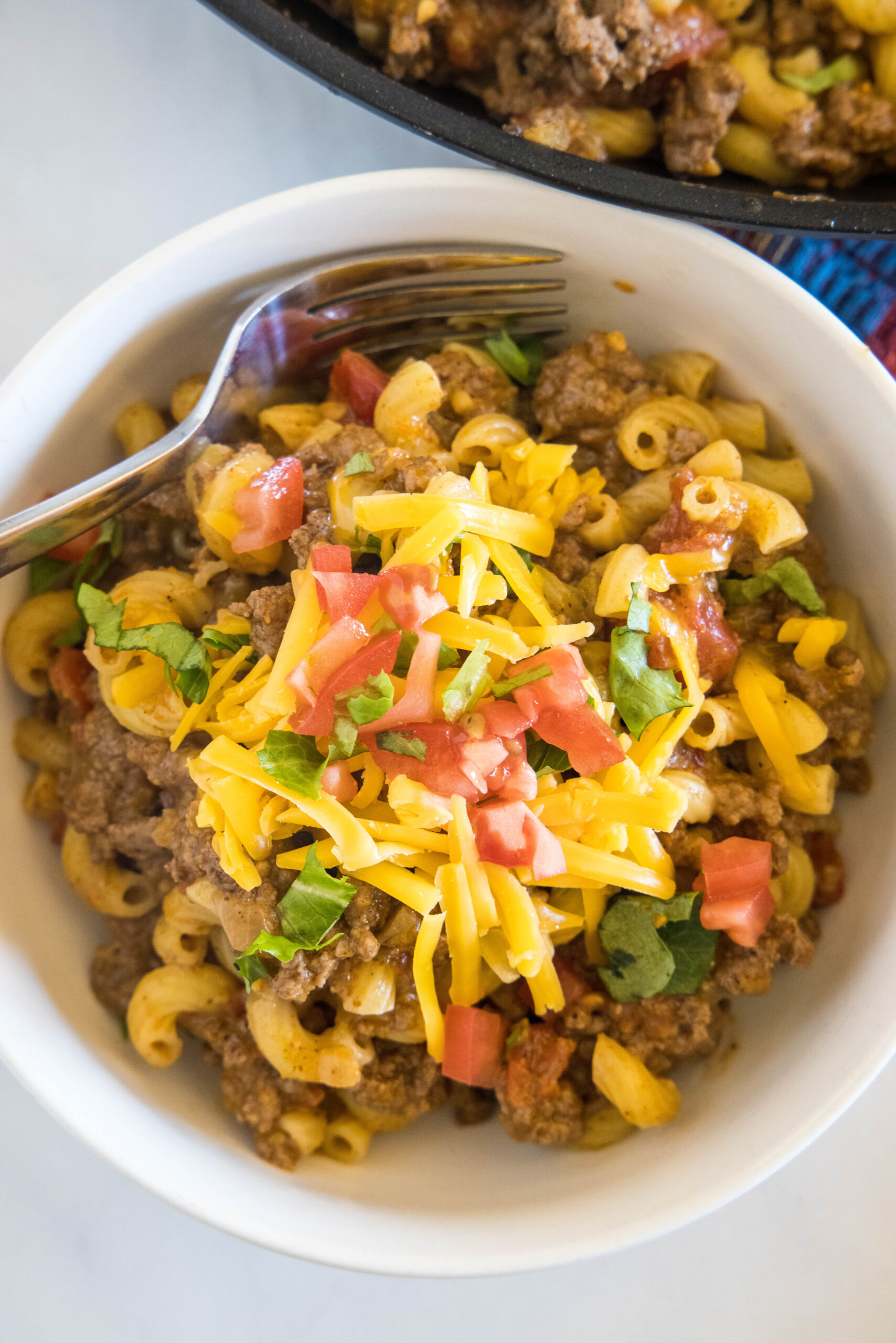 Overhead view of a bowl of taco mac and cheese with a fork.