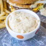 Big Mac Sauce in a small serving bowl, with a burger and fries in the background.