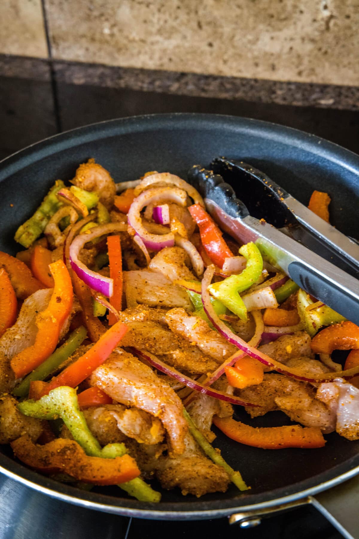 cooking chicken fajitas in a skillet