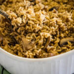close up french onion rice scooping out of baking dish