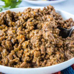 Slow cooker taco meat in a large white bowl.