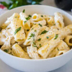 Crock pot chicken alfredo served in a white bowl.