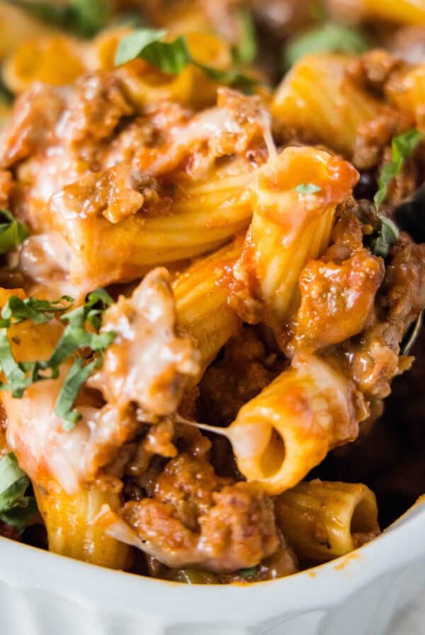 close up scooping sausage casserole out of baking dish