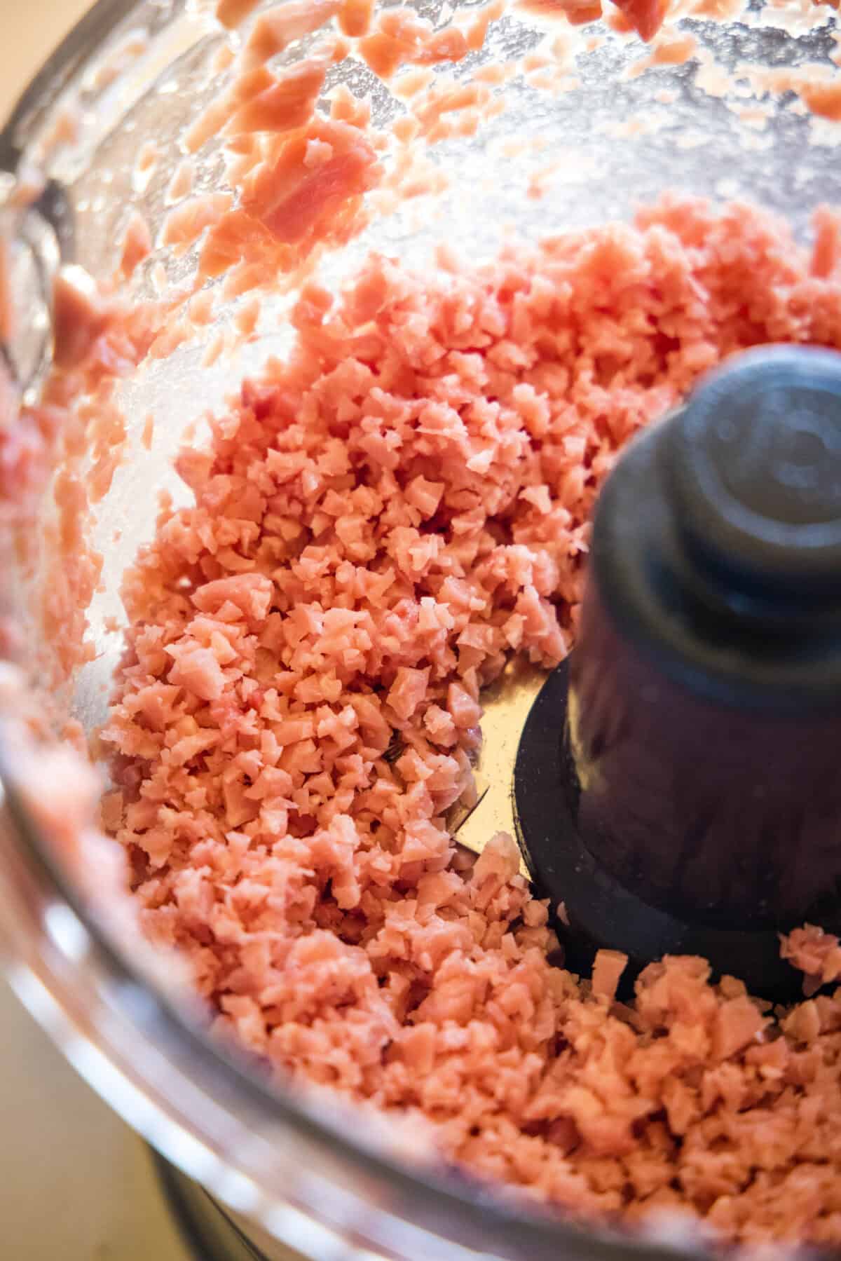 Ham meatball mixture minced inside a food processor.