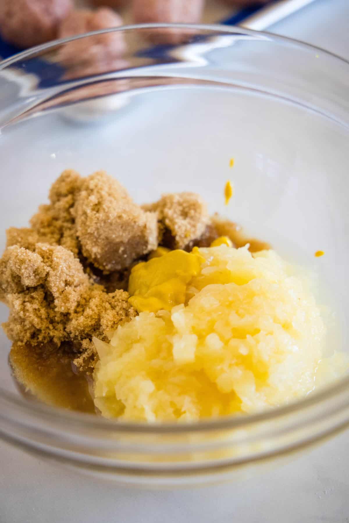 Brown sugar and crushed pineapple combined with the sauce ingredients in a glass bowl.