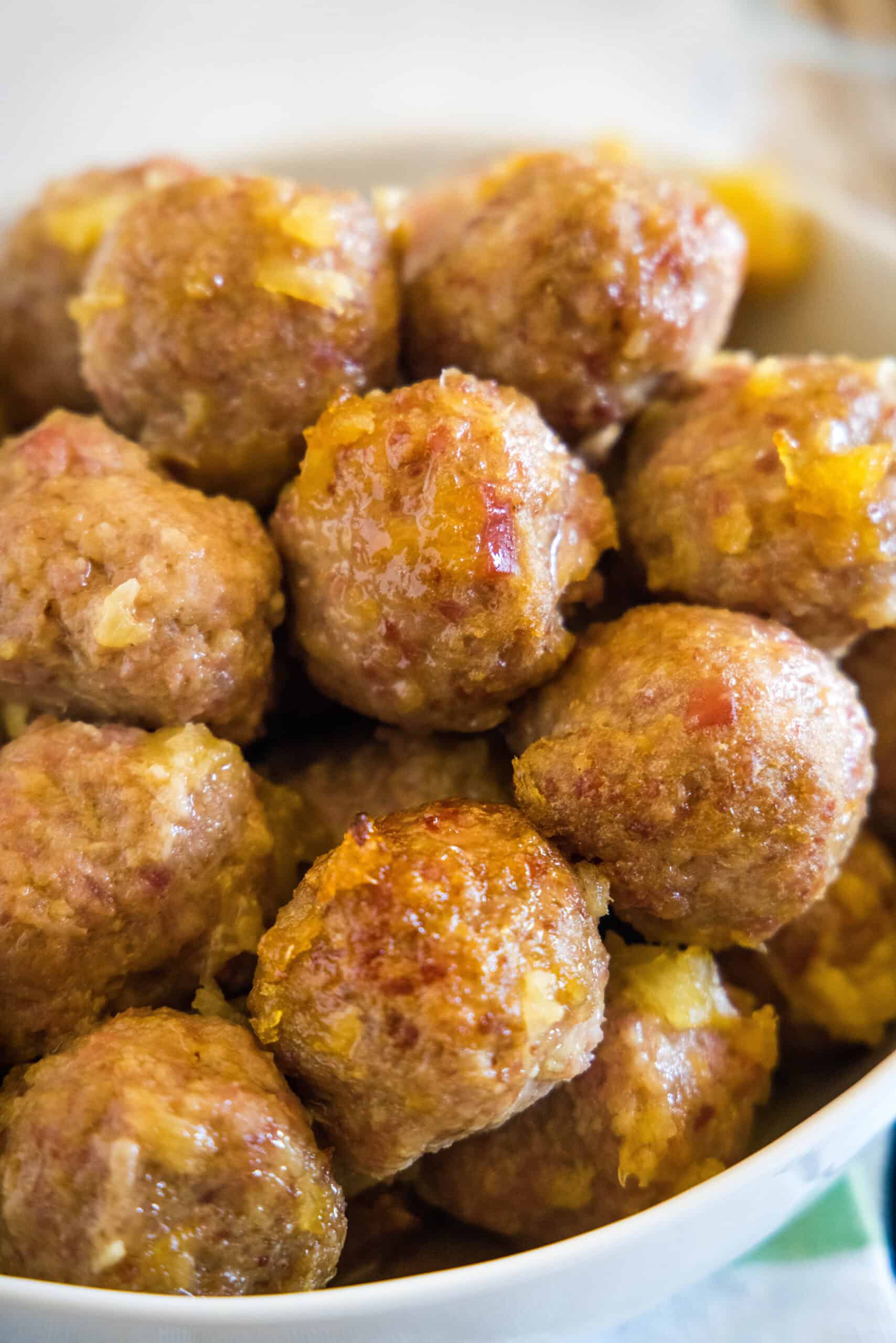 Ham balls with pineapple sauce piled into a bowl.