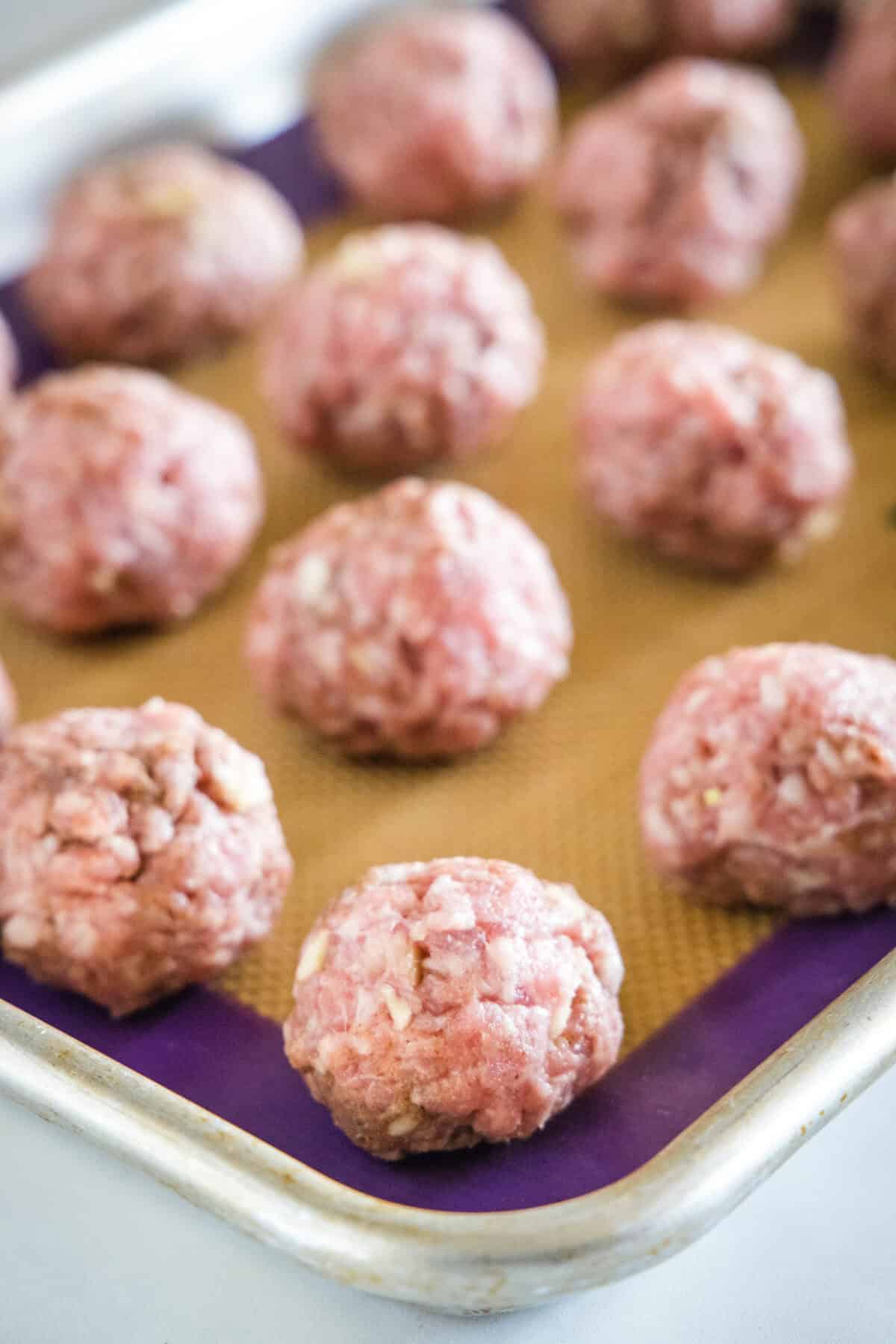 Asian Meatballs with Spicy Rice Noodles asian meatballs on a baking sheet ready for the oven