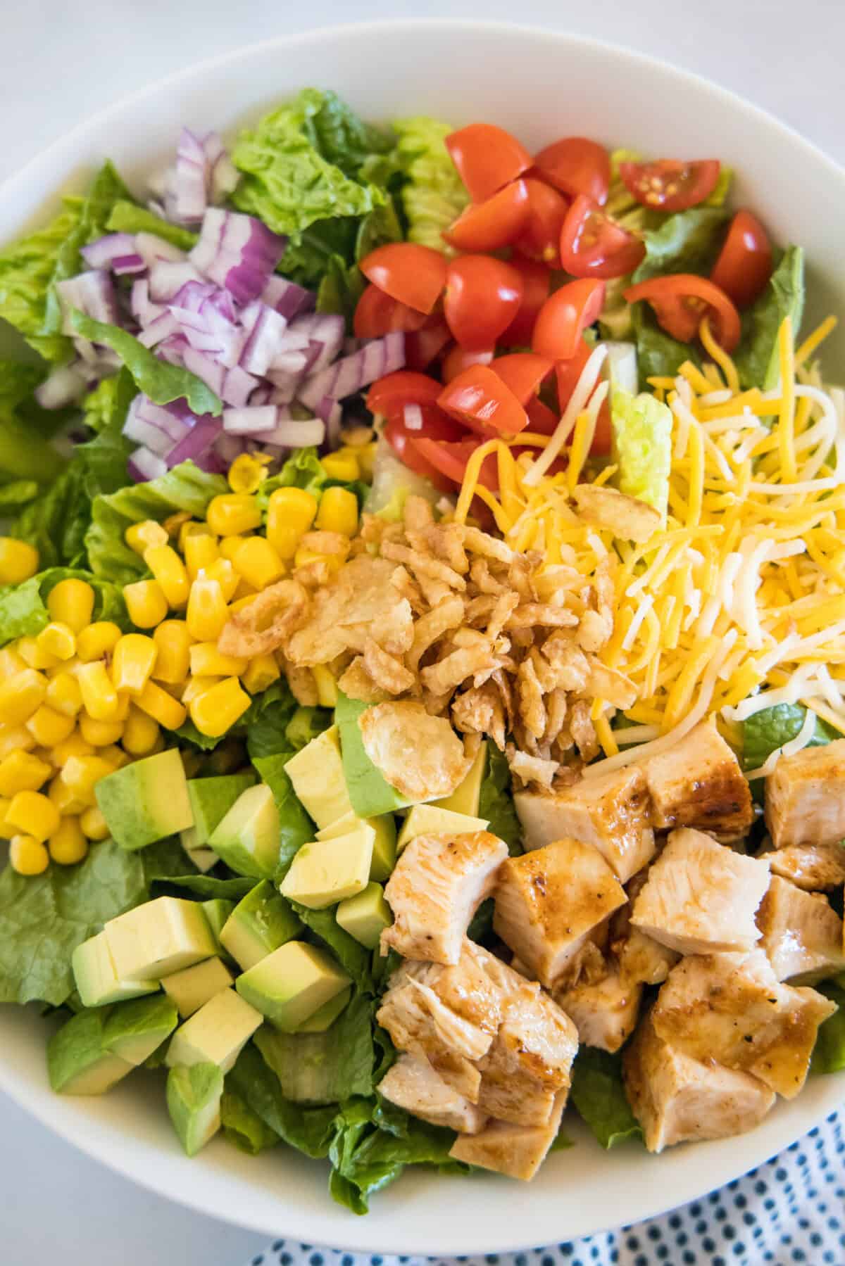 Overhead view of a BBQ chicken salad assembled in a bowl.