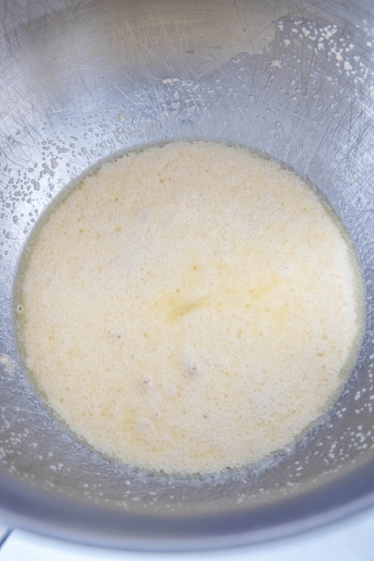 Yeast activated with sugar and water in a metal bowl.