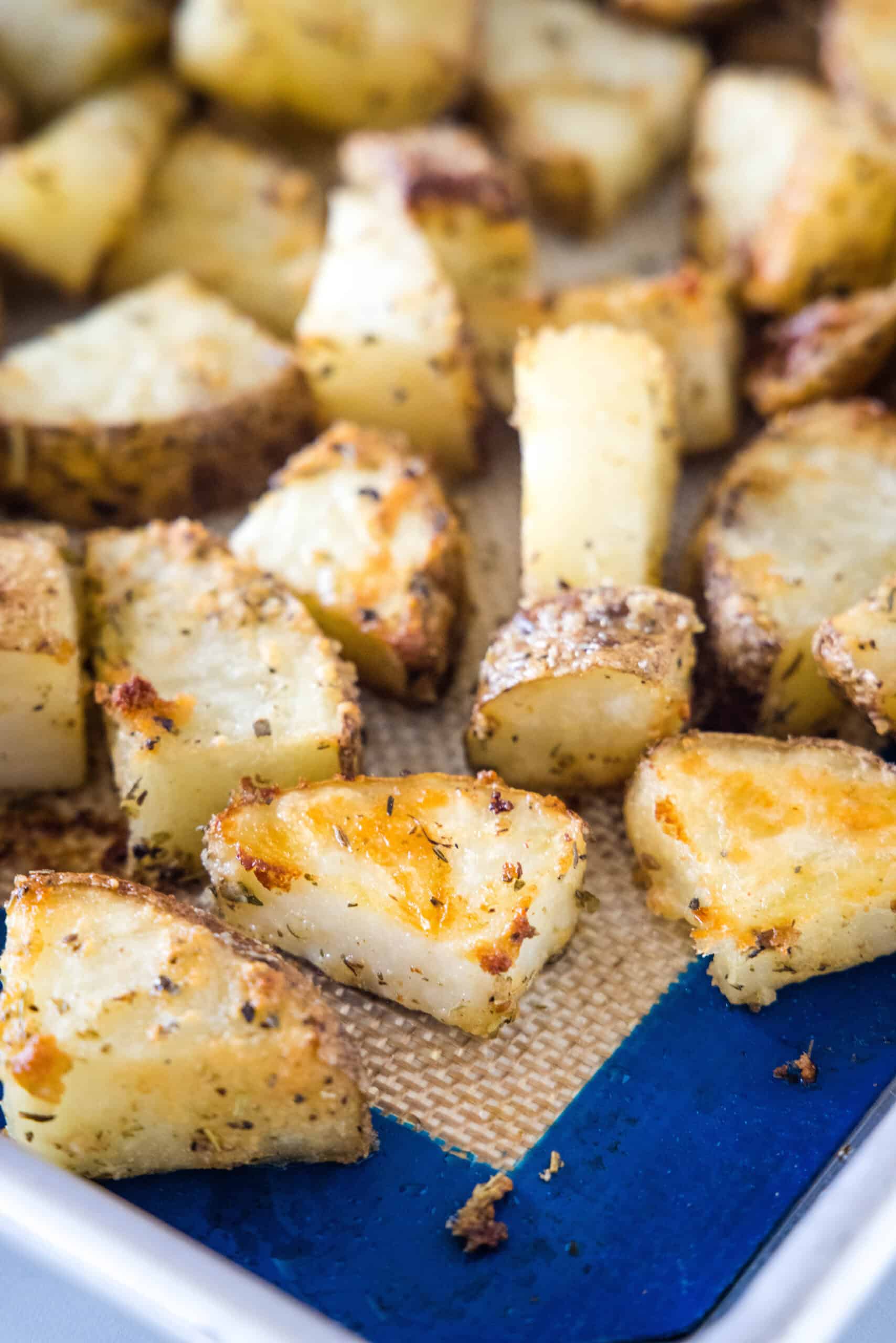 Close up of seasoned oven roasted potatoes on a baking sheet.