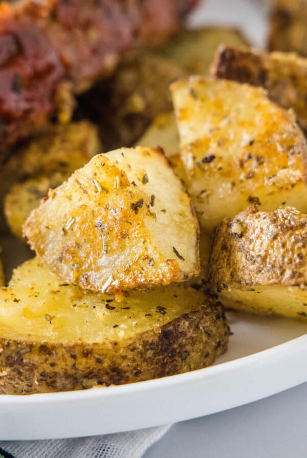 Close up of seasoned oven roasted potatoes on a plate.