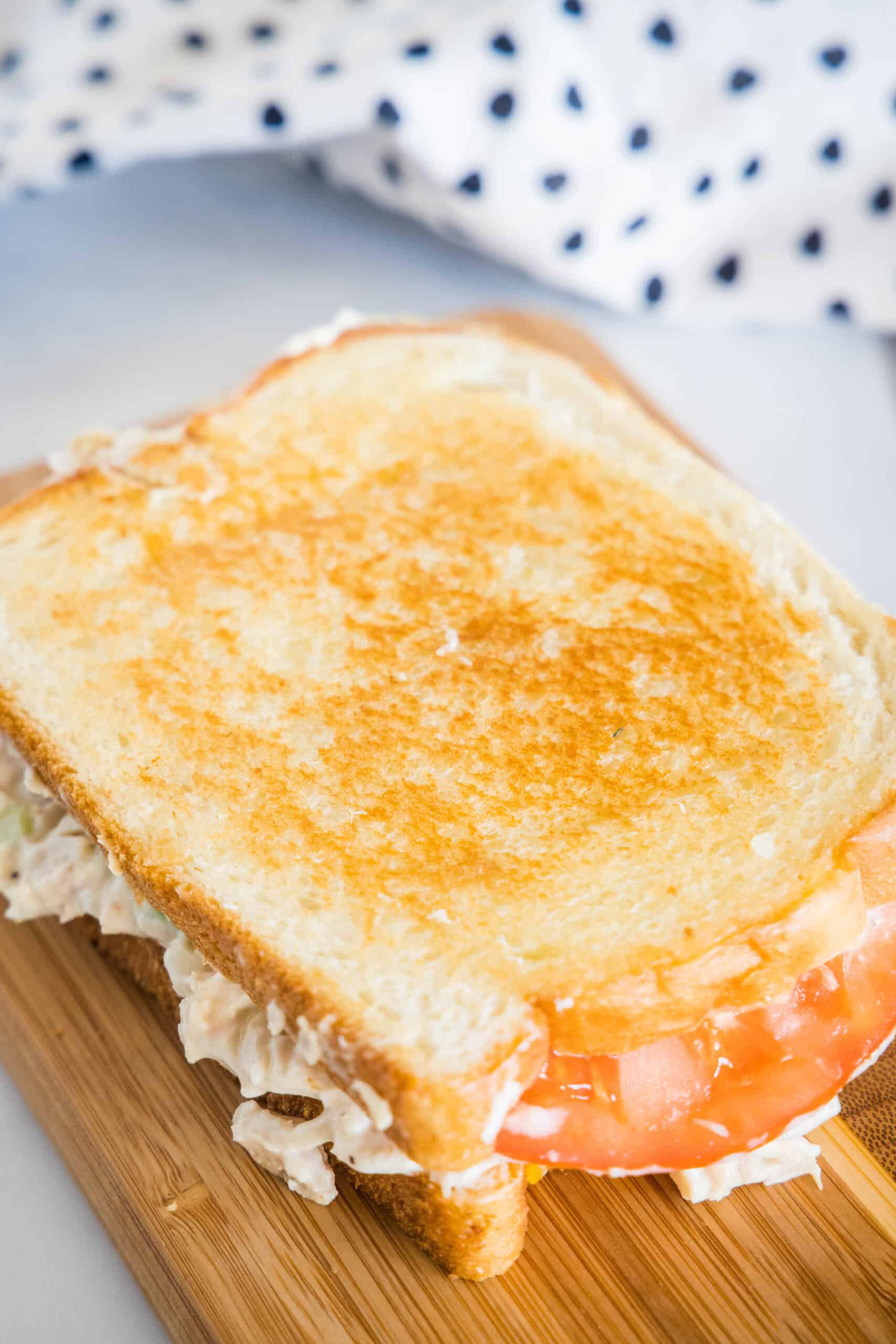 Overhead view of a tuna melt on a wooden platter.