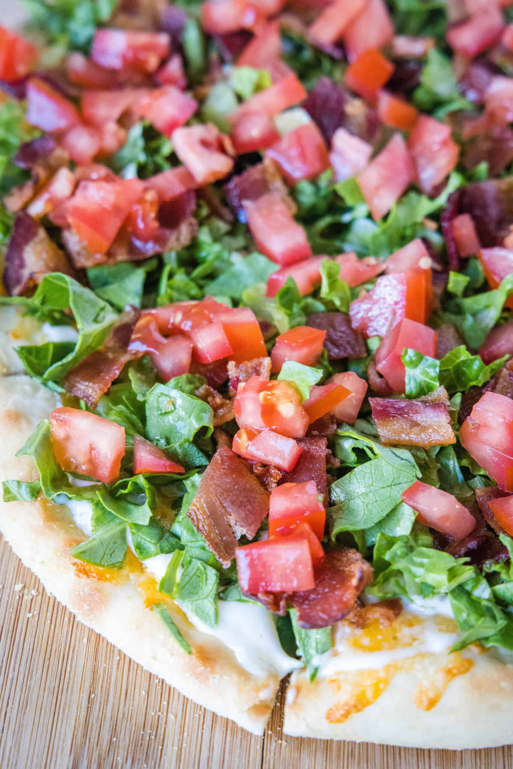 This BLT pizza recipe reimagines a classic bacon, lettuce, and tomato sandwich into a delicious, cheesy, and flavor-packed homemade pizza! Close up of a BLT pizza.