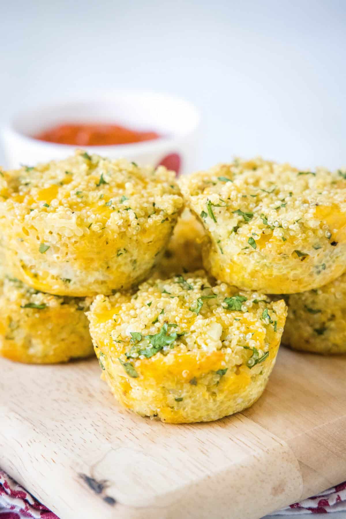 Crispy Quinoa Bites cheesy quinoa bites on a board with marinara sauce